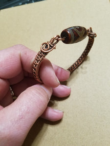 Slender woven copper bracelet with gemstone bead clasp